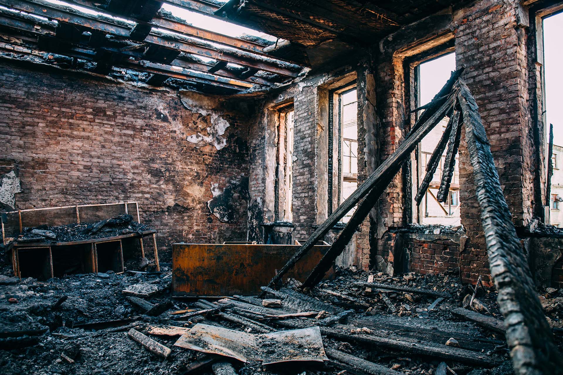 Burnt room interior with walls, furniture and floor in ash.