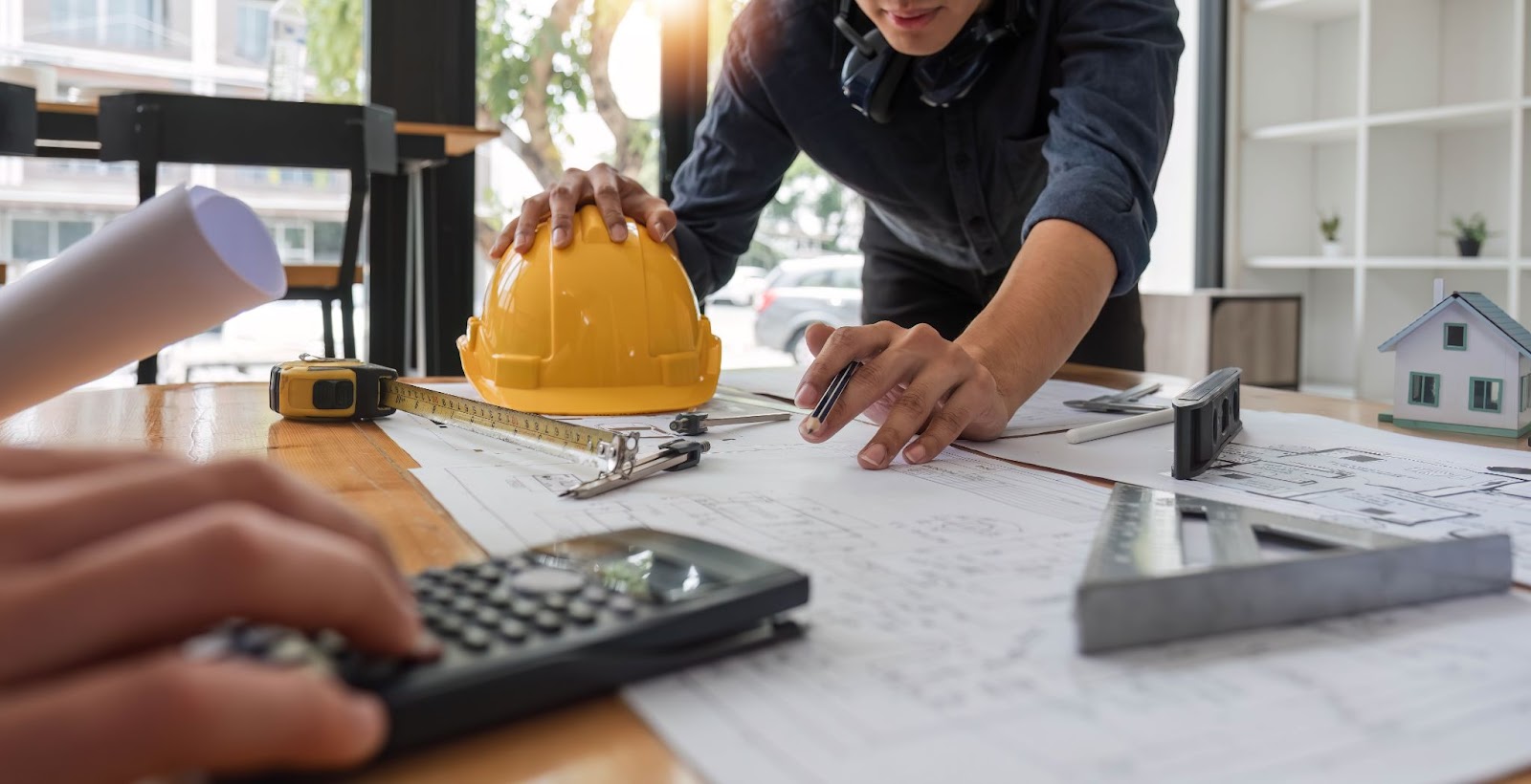 Two engineers are in a team meeting to draft their construction plan.