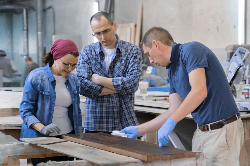 Workers at the carpentry shop varnished a wooden plank.