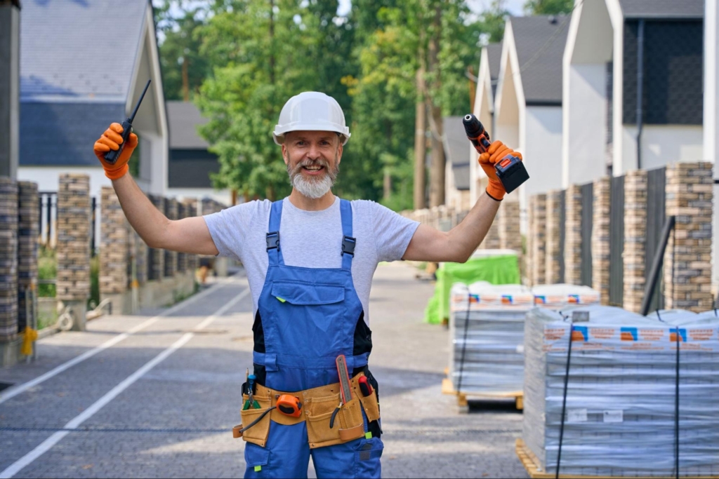 A happy building contractor poses for the camera, showing joy after completing a project.