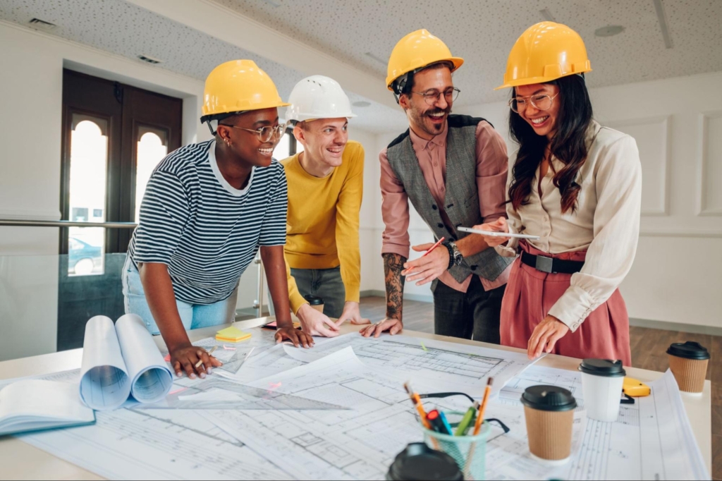 A team of young engineers laughed while discussing their plans.