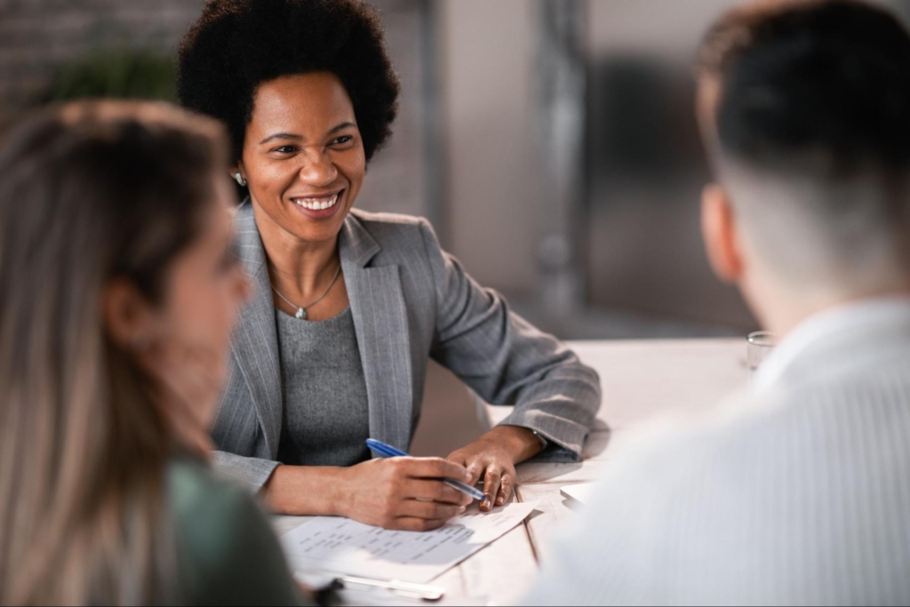 A smiling female insurance agent confidently presented the plans to her clients.