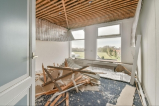 Room with broken pieces of wood and extensive damage.