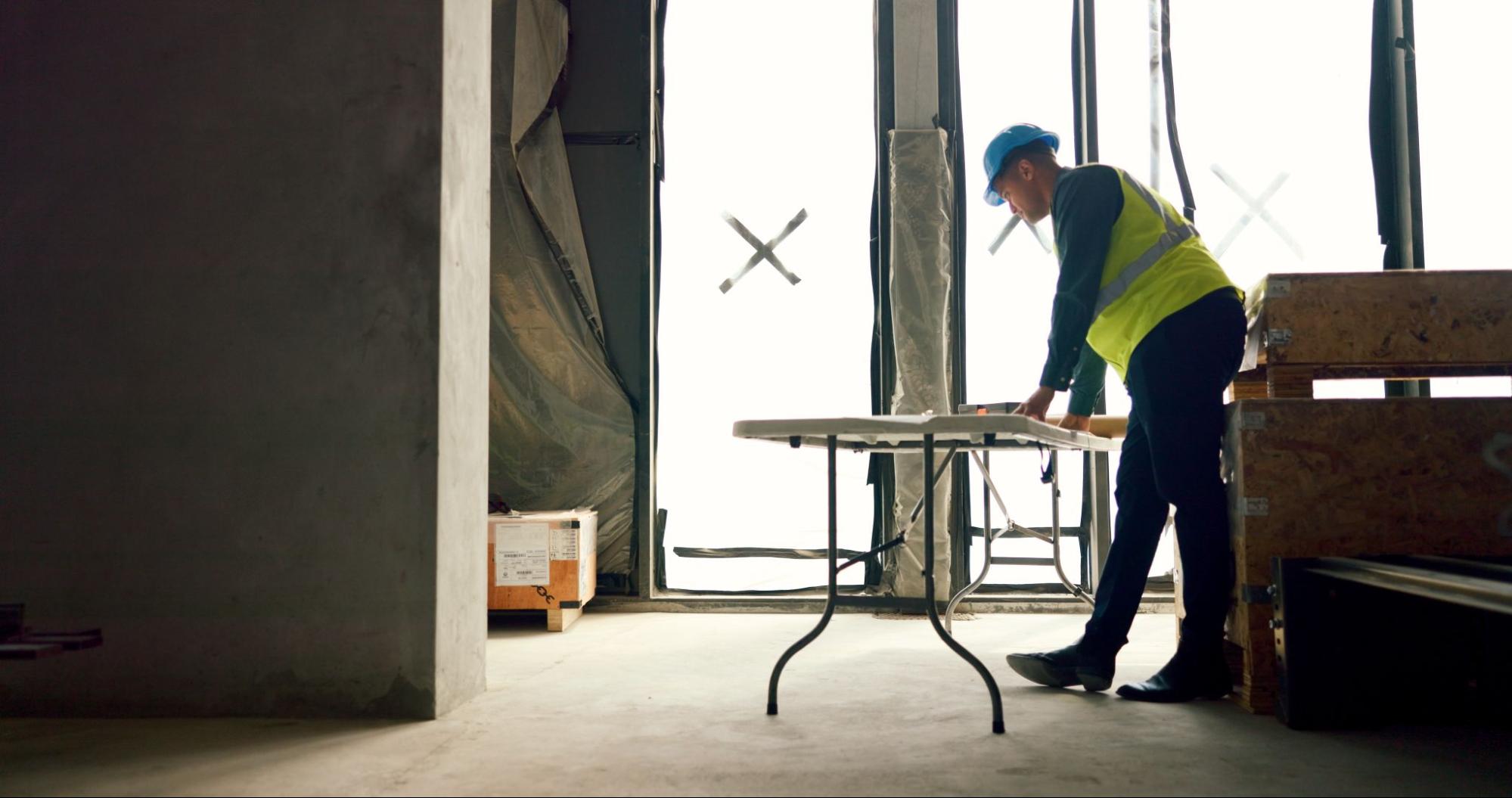 Construction worker next to a table. 